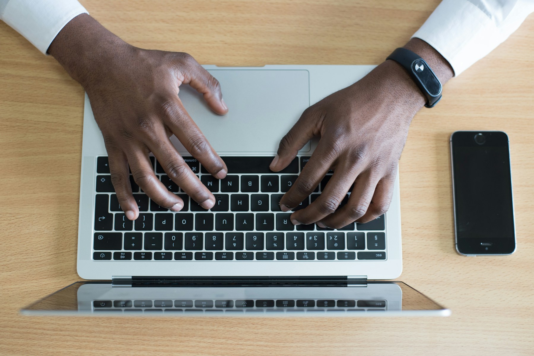 A bright desk setup with a Mac and iPhone ready to work together.